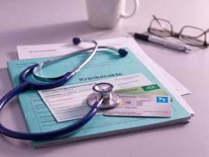 Stethoscope on German health insurance documents and medical forms on desk, representing healthcare consultation and medical guidance.